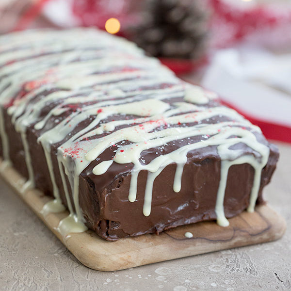 A keto chocolate pound cake topped with white icing and sprinkles